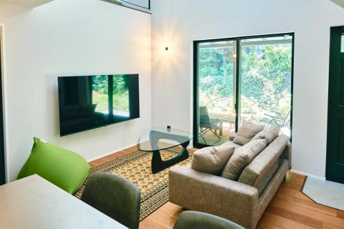 a living room with a couch and a table at Neverland Garden B棟 - 山の中の別荘一棟貸切 in Ichigaya