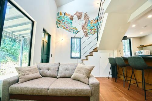 a living room with a couch and a staircase at Neverland Garden B棟 - 山の中の別荘一棟貸切 in Ichigaya