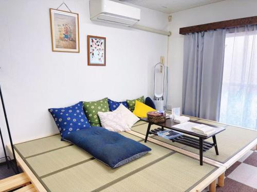 a living room with a blue couch and a table at Direct to Shinjuku 15 mins 3rooms Up to 9 Guests in Tokyo