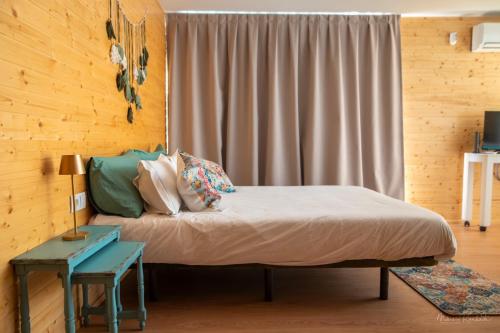a bedroom with a bed and a table and a window at Bungalow da Romy in Vila Praia de Âncora