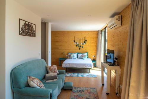a bedroom with a bed and a couch and a chair at Bungalow da Romy in Vila Praia de Âncora