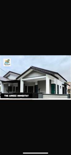 a large white house with the words the attic inventory at The Aireez Homestay in Batu Lima
