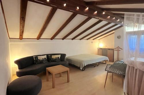 een woonkamer met een bank en een bed bij Casa Foresta in Maggia