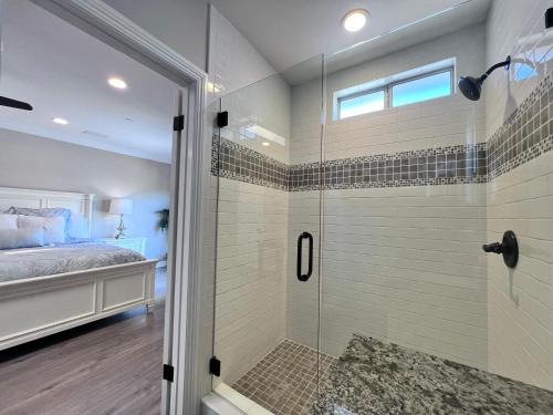 a bathroom with a walk in shower next to a bed at Destination #32 in Anaheim