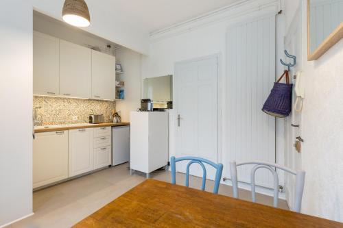 une cuisine avec une table, des chaises et un réfrigérateur dans l'établissement Arlequin by Cocoonr, à Rennes