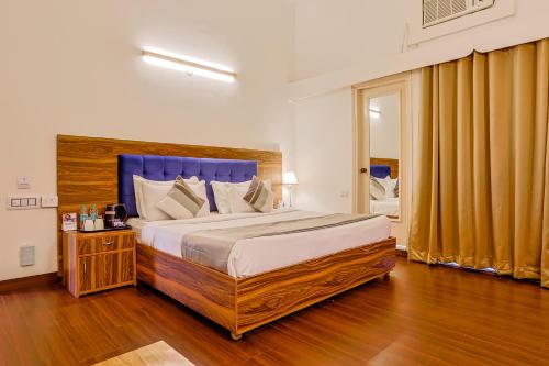 asar CP Outer Circle by Orion Hotels في نيودلهي: غرفة نوم بسرير كبير مع لوح رأس أزرق