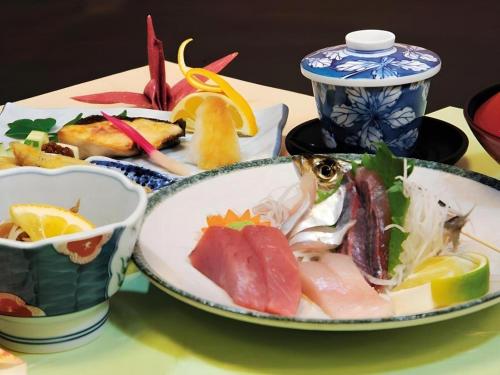 a table with two plates of food on it at AKISAWA HOTEL in Sukumo