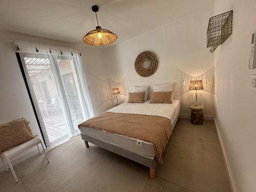 a bedroom with a bed and a large window at Les Villas de Fiori Di Cala Rossa in Lecci