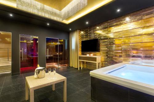a large bathroom with a tub and a tv at Pine Cliffs Village in Albufeira