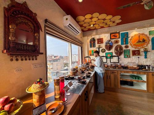 a man standing in a kitchen preparing food at The Neeraj Ganga Rajmahal Wellness Dream in Rishīkesh