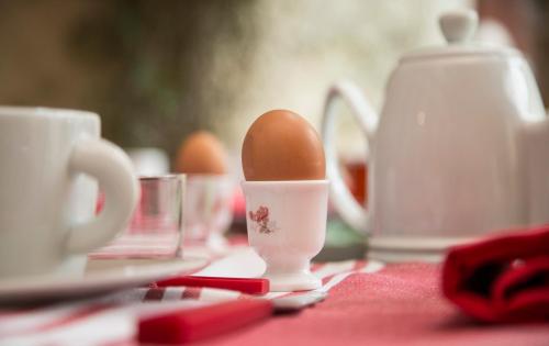 un uovo in una tazza sopra un tavolo di Le clos des abeilles a Ruch