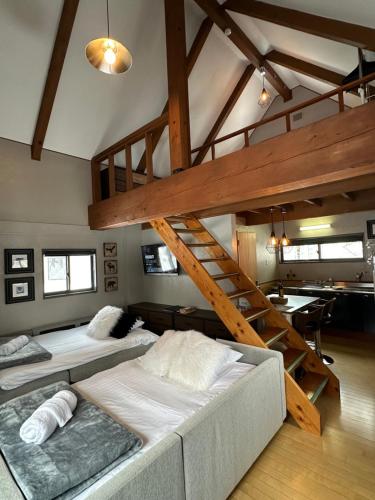 Un dormitorio con dos literas y una escalera. en Casa Bell Cabin Niseko, en Niseko
