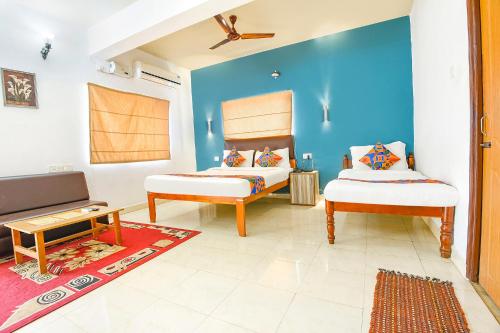 カンドリムにあるFabHotel Benz Destination - 700m Candolim Beachのリビングルーム(ベッド2台、テレビ付)