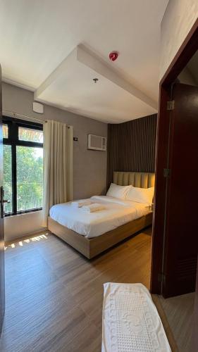 a large bedroom with two beds and a window at Arpo Hotel San Juan La Union in San Juan