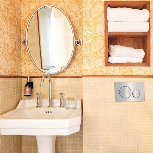 a bathroom with a sink and a mirror and towels at Hôtel Amista Marseille in Marseille