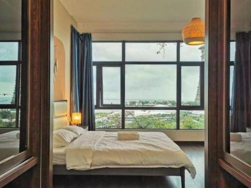 a bedroom with a bed and a large window at Yussy Homestay at Cerulean Bay Forest City in Kampong Tanjong Kupang