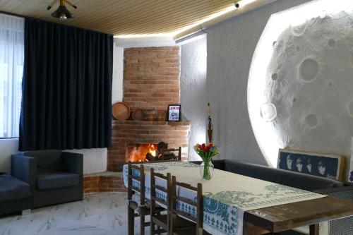 a living room with a table and a fireplace at Khando's Resort in Passanauri