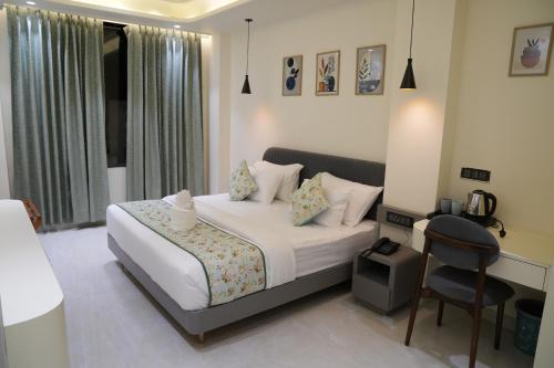 a bedroom with a bed and a chair in it at Hotel ARCHWAY By SOMU'S PRIMS in Jaipur