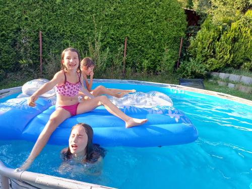 two girls in the water on an inflatable raft in a swimming pool at Amálkin Dvor in Podbrezová