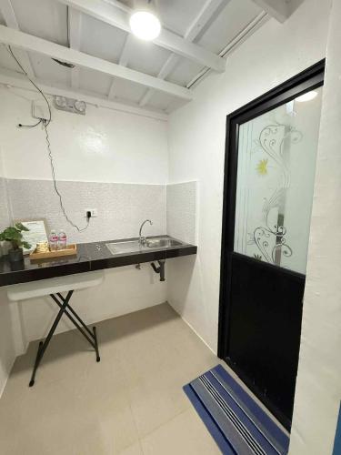 ein Badezimmer mit Waschbecken und Glasdusche in der Unterkunft Arzel's Tiny House in Mangatarem