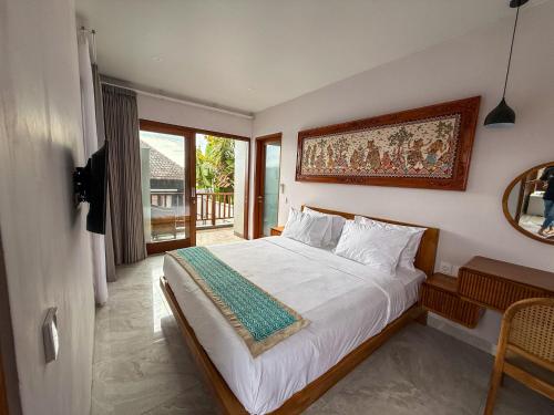 a bedroom with a large bed and a mirror at Rahayu Guest House Seminyak in Seminyak