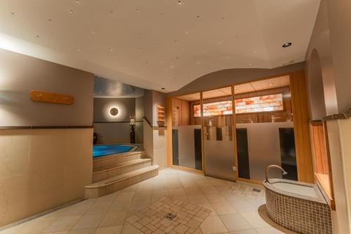 a bathroom with a bath tub and a sink at Hotel Ulli in Zürs am Arlberg