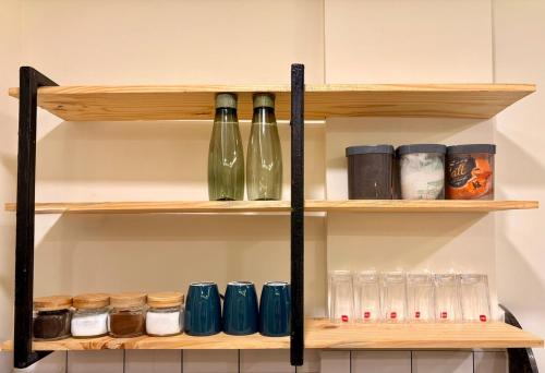 a shelf with wine bottles and jars on it at Aesthetic 1BHK, Indore in Indore