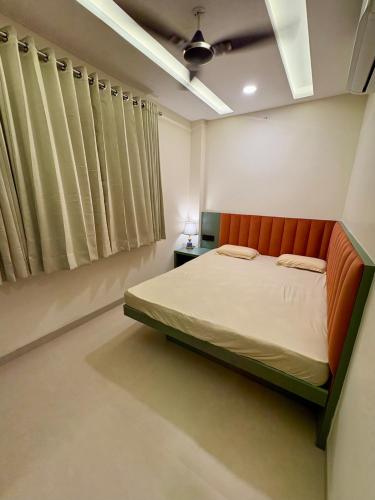 a bedroom with a bed with an orange headboard at Aesthetic 1BHK Elite, Indore in Indore