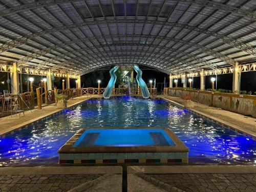 a swimming pool with blue water in a building at Arzel's Tiny House in Mangatarem