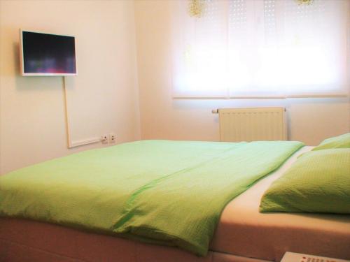 a bedroom with a green bed with a window at Luma Apartment in Zagreb
