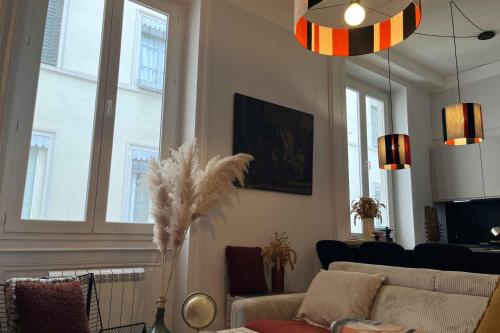 Una sala de estar con un sofá y algunas ventanas. en Bright and comfortable stay in the heart of Lyon, en Gare des Brotteaux