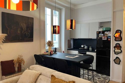 Una sala de estar con una mesa y una cocina. en Bright and comfortable stay in the heart of Lyon, en Gare des Brotteaux