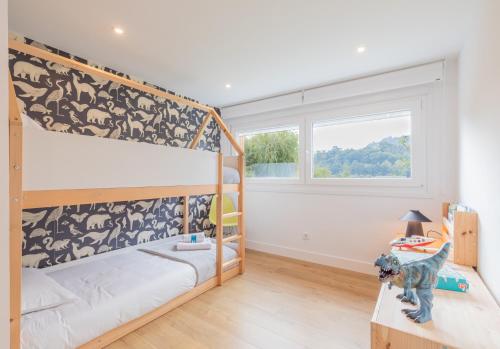 a bedroom with two bunk beds and a dog on a table at Errekaondo - baskeyrentals in Plentzia