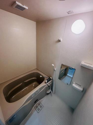 a bath tub in a bathroom with a window at U&T V-Five Room-306 in Beppu