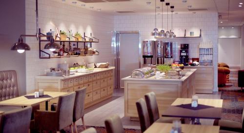 a restaurant with tables and chairs in a room at Home Hotel Astoria in Hamar