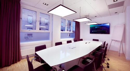 a conference room with a white table and chairs at Home Hotel Astoria in Hamar