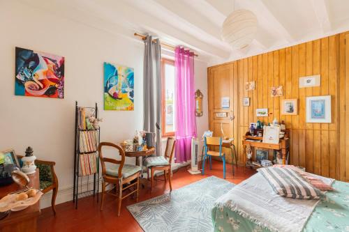 a bedroom with a bed and a table and chairs at Le Jardin Pictural De Garance in Chédigny