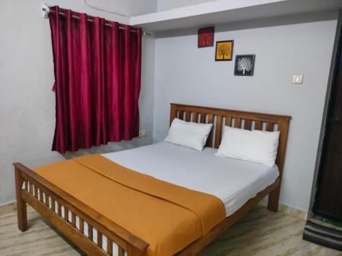 a bed in a room with a red curtain at Shree Stay in Anjuna
