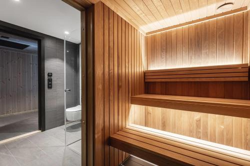 een badkamer met houten wanden en een inloopdouche bij Brand new luxury apartment by the slopes, Hemsedal in Kyrkjebøen