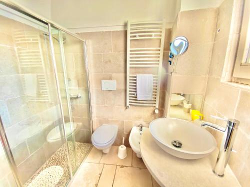 Un baño con ducha, lavabo e inodoro. en Trullo Stella Luxury Trullo, en Alberobello