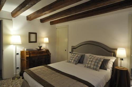 a bedroom with a large bed and two lamps at Casa Colleoni in Venice