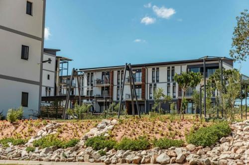 ein Mehrfamilienhaus mit einem Garten davor in der Unterkunft Grey Heaven Retreat in Boschrand