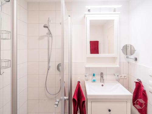 a white bathroom with a shower and a sink at Ferienwohnung Kuckucksnest in Unterkirnach