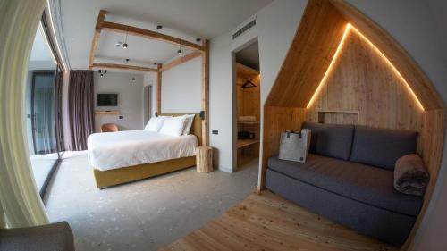 a bedroom with a bed and a couch in a room at Agritur Lawanda in Vezzano