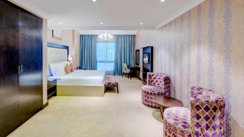 a hotel room with a bed and two chairs at Donatello Hotel in Dubai