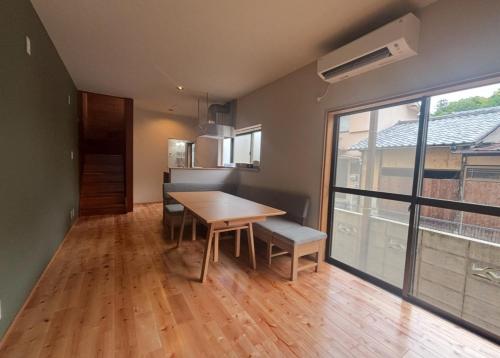 a dining room with a table and a large window at P-Stay宮島中西町 in Hatsukaichi