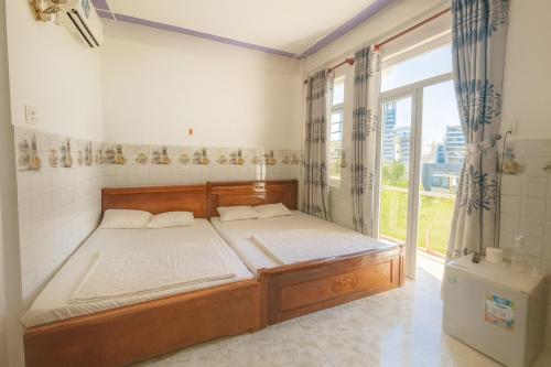 a bedroom with a bed and a large window at Ngọc Trung Hotel in Quy Nhon