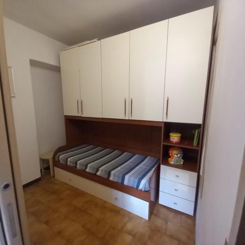 a small bedroom with white cabinets and a bed at CasaEndine in Ranzanico