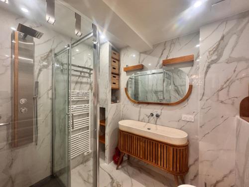 a bathroom with a sink and a glass shower at Appartement Le Millie 3 chambres Hyper centre in Calvi