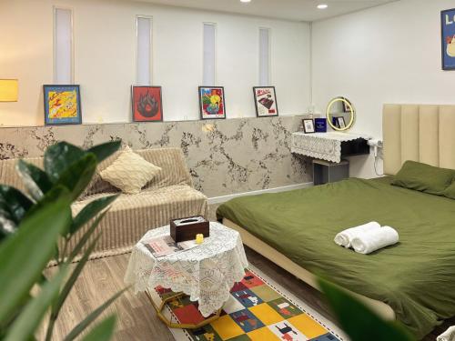 a room with a bed and a couch and a table at De'Lea Homestay & Hotel in Ho Chi Minh City